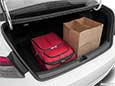 A picture displaying how roomy the Honda Civic trunk space is in the new 2022 model with a full sized suitcase and grocery bags.